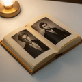 An open vintage photo album with black and white portraits in yellowed sleeves